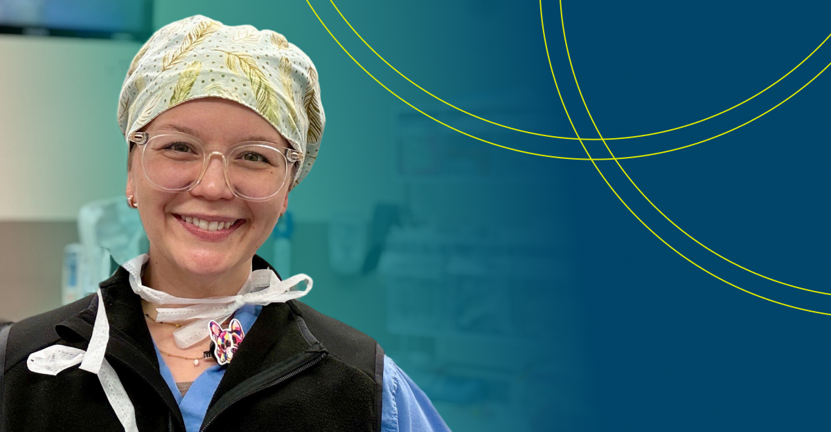 Smiling healthcare professional wearing surgical scrubs, a scrub cap, and protective glasses in a clinical setting, representing onboarding for travel clinicians.